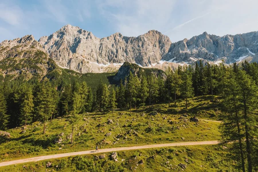 Sommerlandschaft in Ramsau am Dachstein mit Wander- und Bikeweg vor dem Dachsteinmassiv