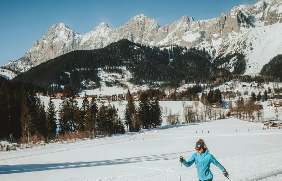 Langläuferin auf der Loipe in Ramsau am Dachstein mit Blick auf das Dachsteinmassiv