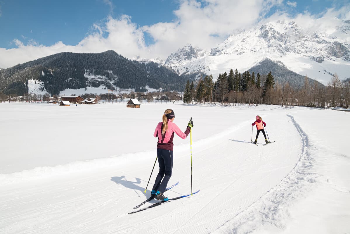 Mutter und Kind beim Langlaufen in der Loipe vor dem Dachstein